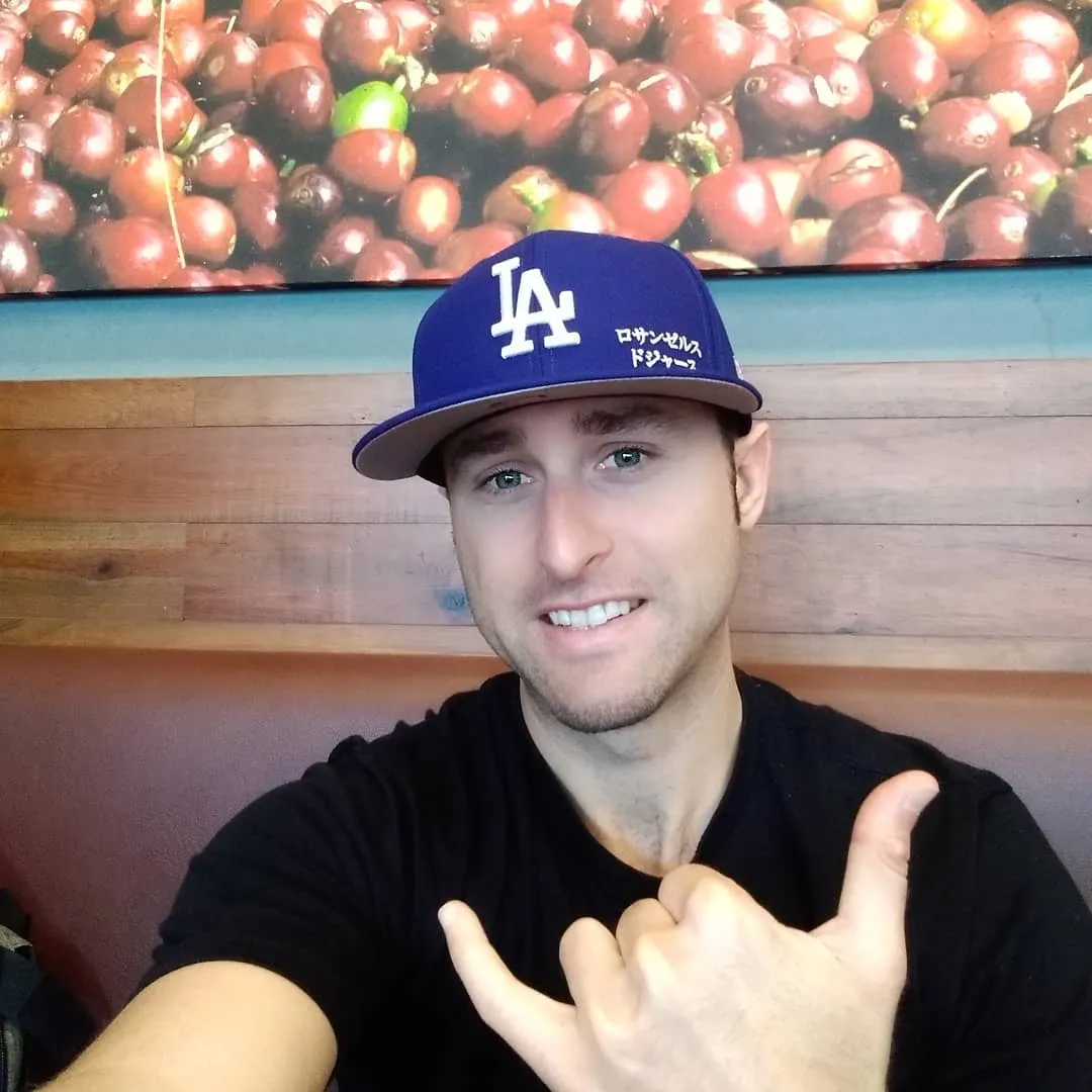 Josh in a Dodgers cap, smiling and throwing a shaka
