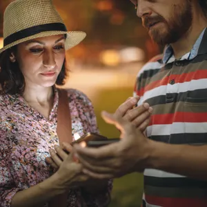 Two people exchanging contact details on their phones