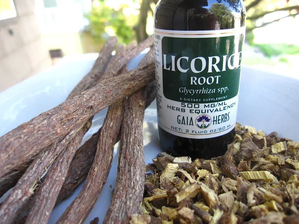 Licorice root sticks next to a bottle of licorice root extract