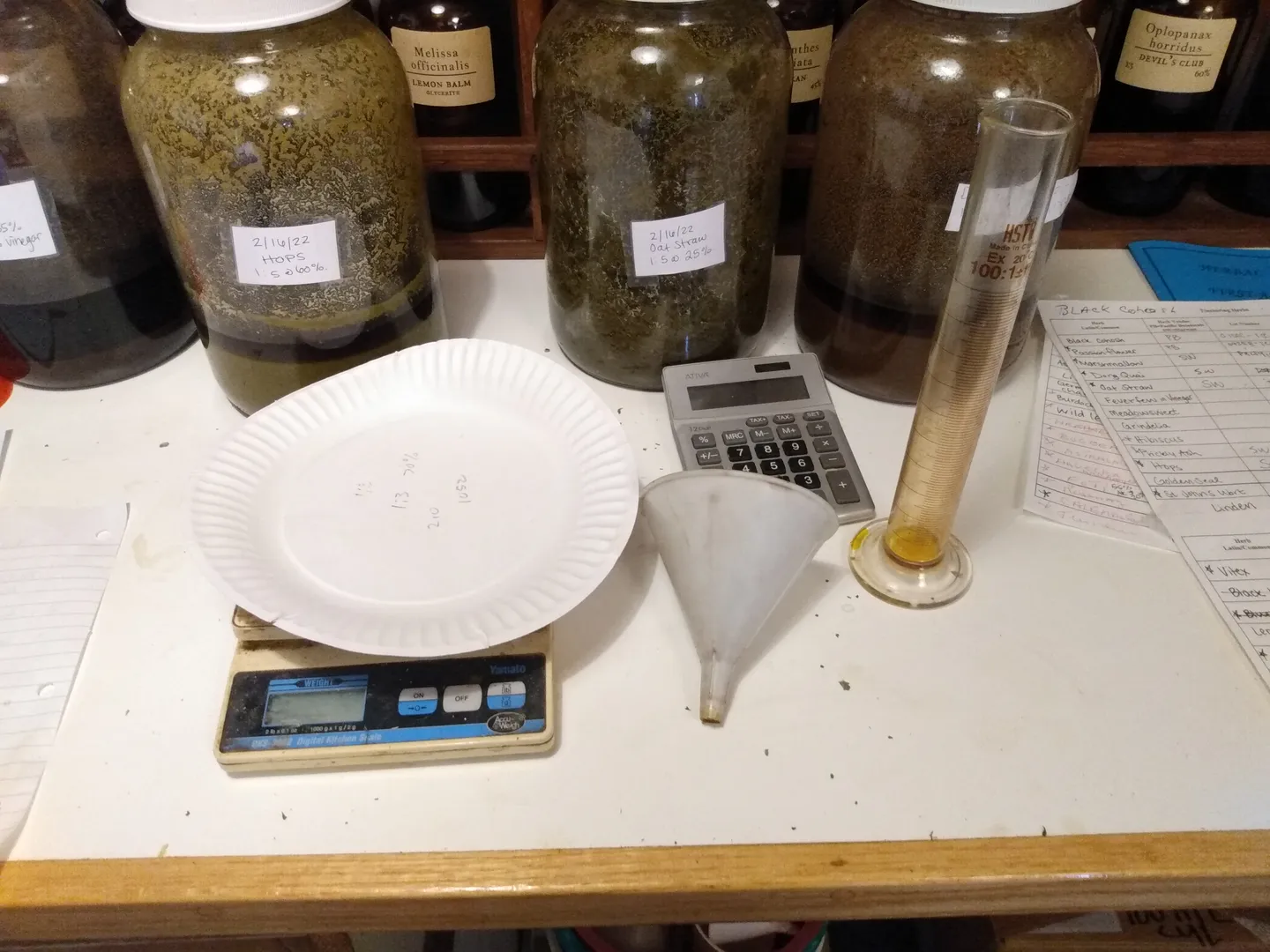 Herb jars, a scale, funnel, calculator and graduated cylinder for making medicine