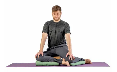 Man in a kneeling hip stretch on cushions