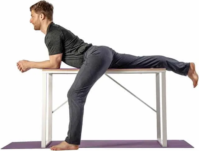 Man doing a psoas stretch with one leg on a table