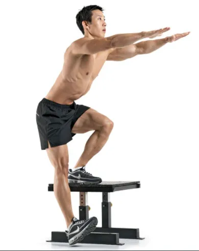 Man doing a chair squat on a box