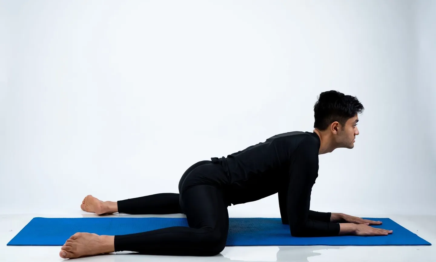 Man in frog pose on a yoga mat