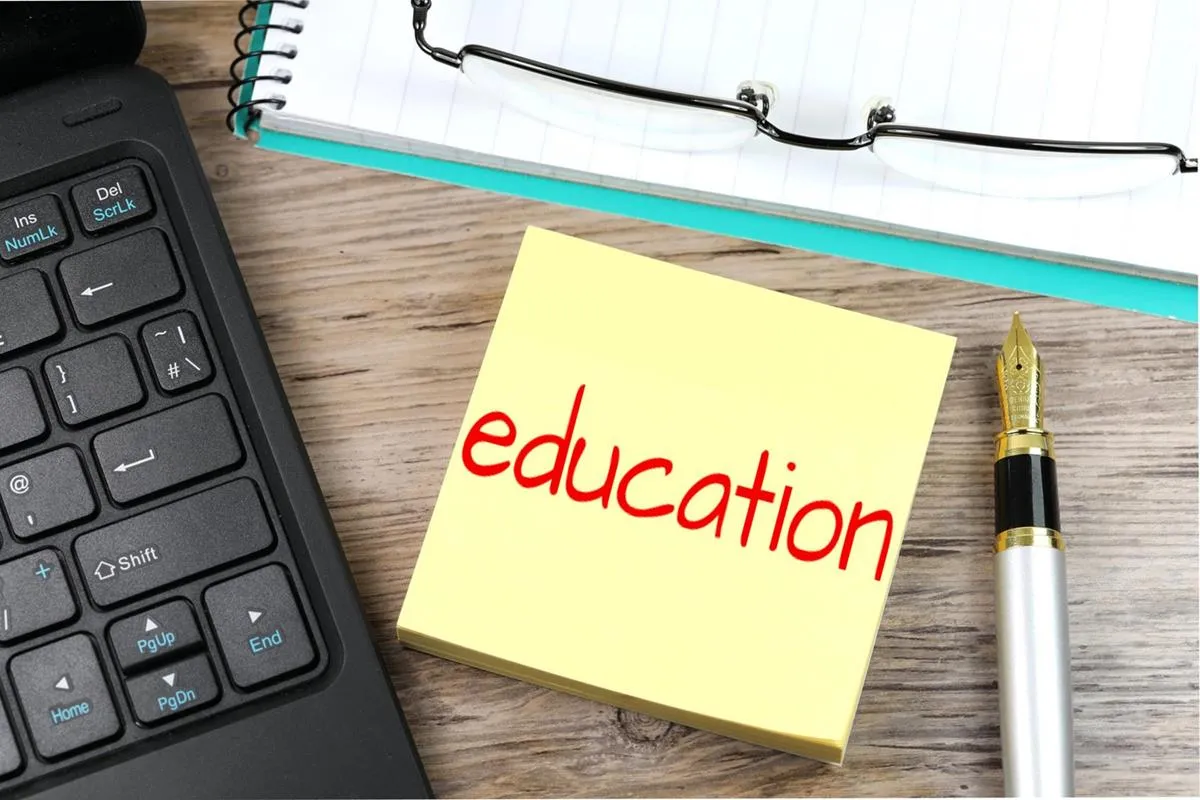 Sticky note reading “education” on a notebook