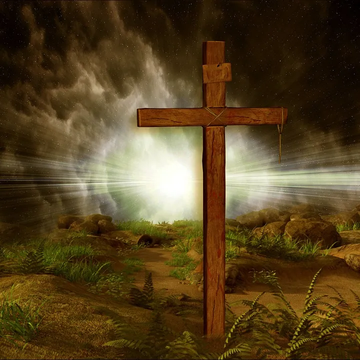 Wooden cross with light shining behind it